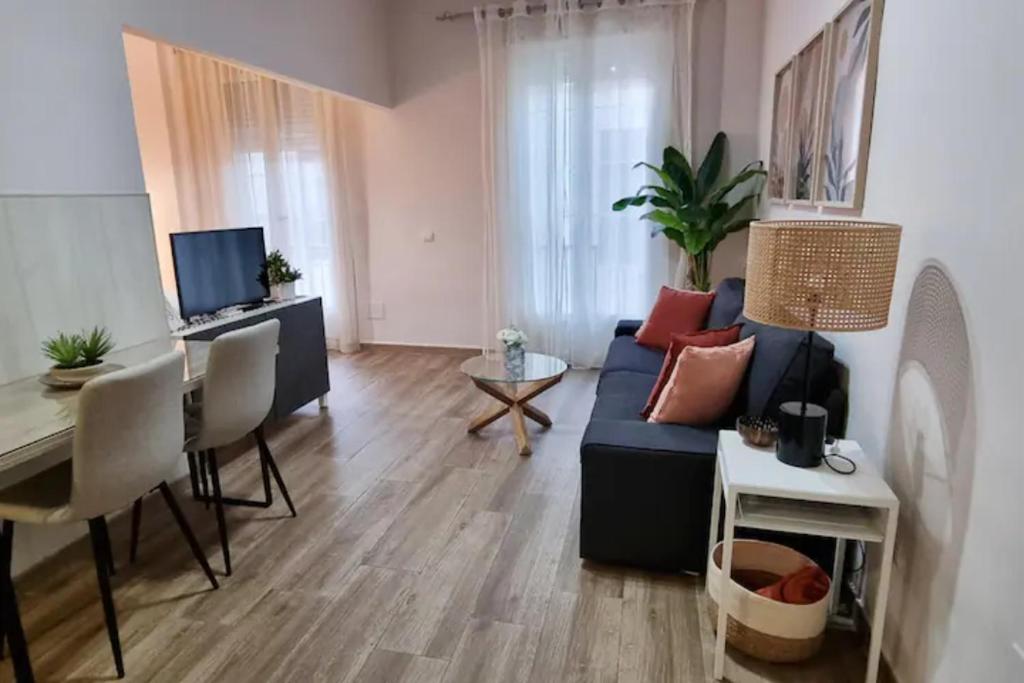 salon z niebieską kanapą i stołem w obiekcie Málaga centro bonito apartamento w Maladze