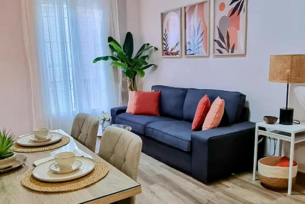 salon z niebieską kanapą i stołem w obiekcie Málaga centro bonito apartamento w Maladze
