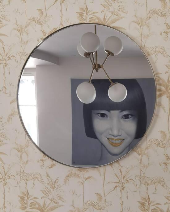 un miroir accroché sur un mur avec une photo d'une femme dans l'établissement Enjoy ArchiLyon by camalan !, à Lyon