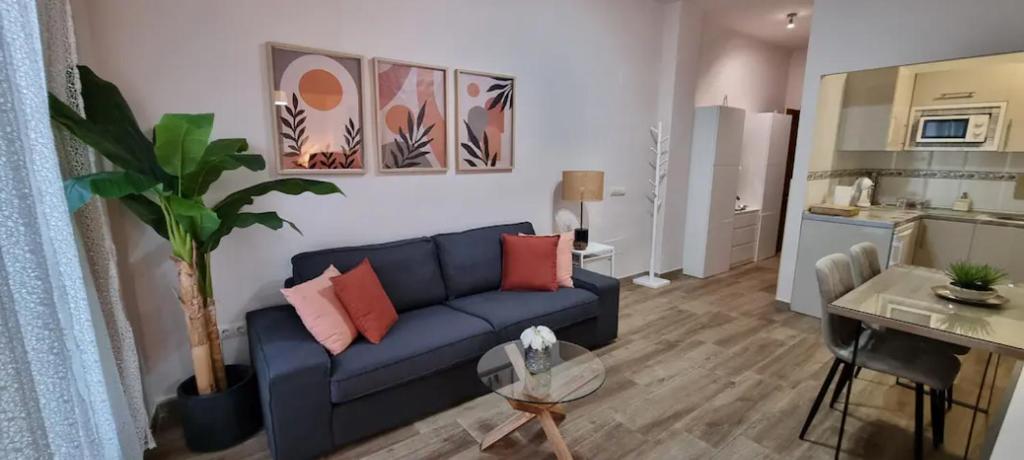 salon z niebieską kanapą i stołem w obiekcie Málaga centro bonito apartamento w Maladze