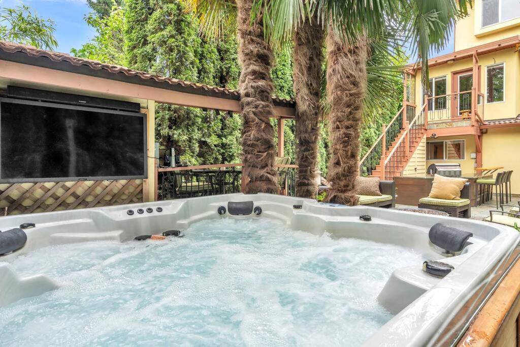 a hot tub in a backyard with palm trees at Luxury Retreat in Vancouver in Vancouver