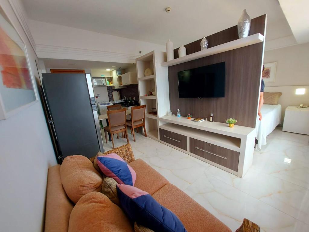 sala de estar con sofá y TV de pantalla plana en Flat Tropical Executive en Manaos