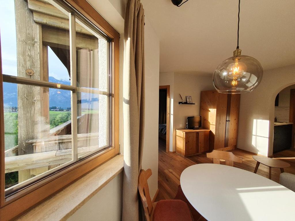 a room with a table and a large window at Gruberwirt Apartment mit Blick auf die Berge GW 4 in Innsbruck