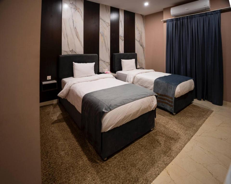 a room with two beds in a room with at Ward Hotel Basra in Al Başrah