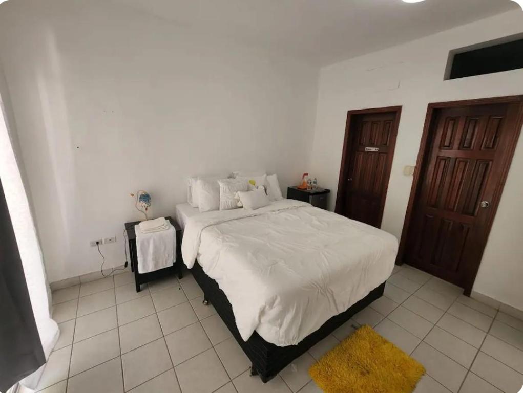a bedroom with a large bed with a yellow rug at Villas L'Hostalet in San Pedro Sula