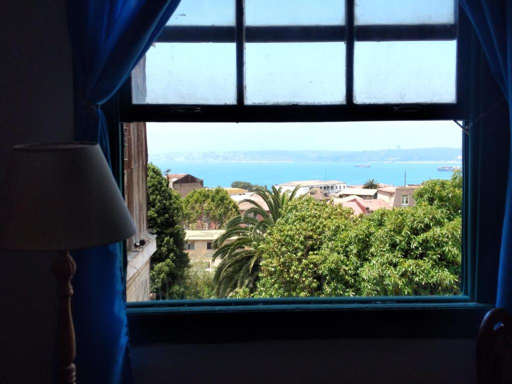 a window in a room looking out at the ocean at República Hostel in Valparaíso