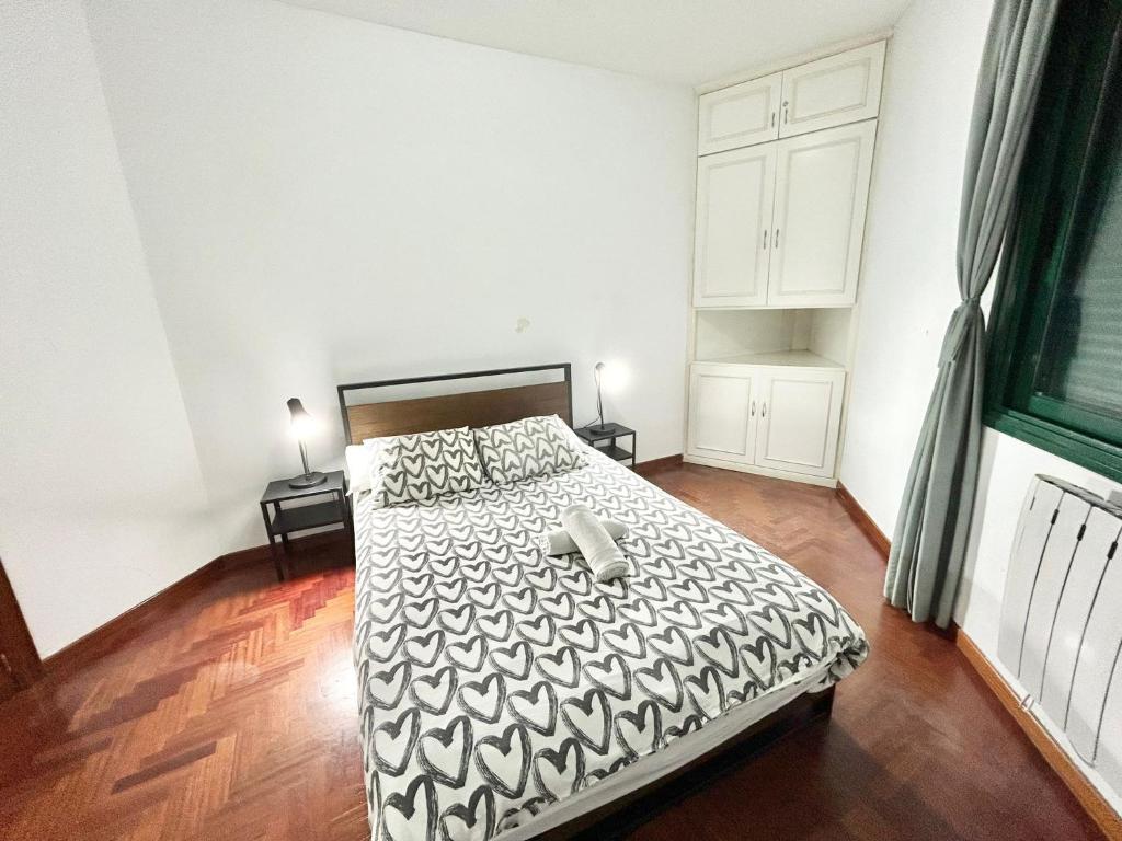 a bedroom with a bed with a black and white comforter at Centro Atocha Méndez Álvaro in Madrid