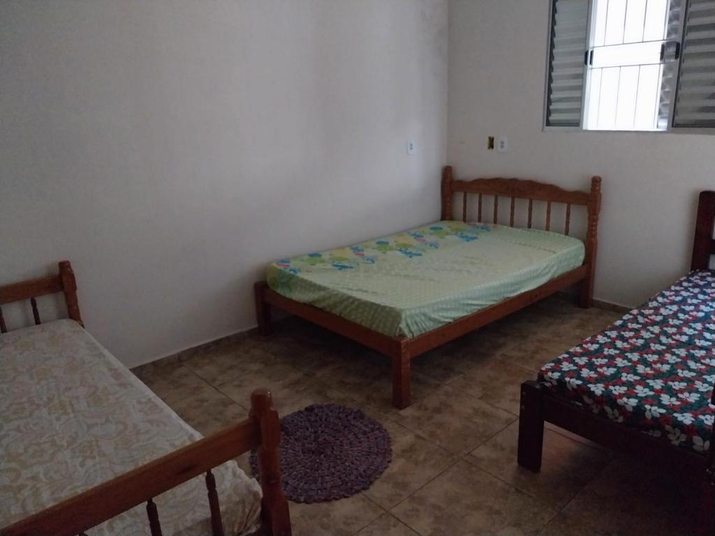 ein kleines Schlafzimmer mit 2 Betten und einem Fenster in der Unterkunft Casa de campo maciel in Abel