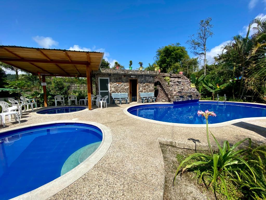 a villa with a swimming pool and a patio at Hostería Arasari in Mindo
