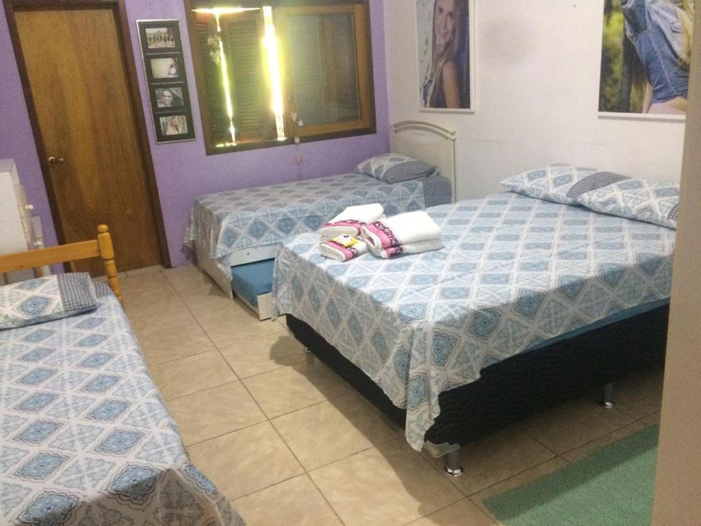 2 camas en una habitación con paredes moradas en Residência familiar com piscina e área de lazer, en São Gabriel