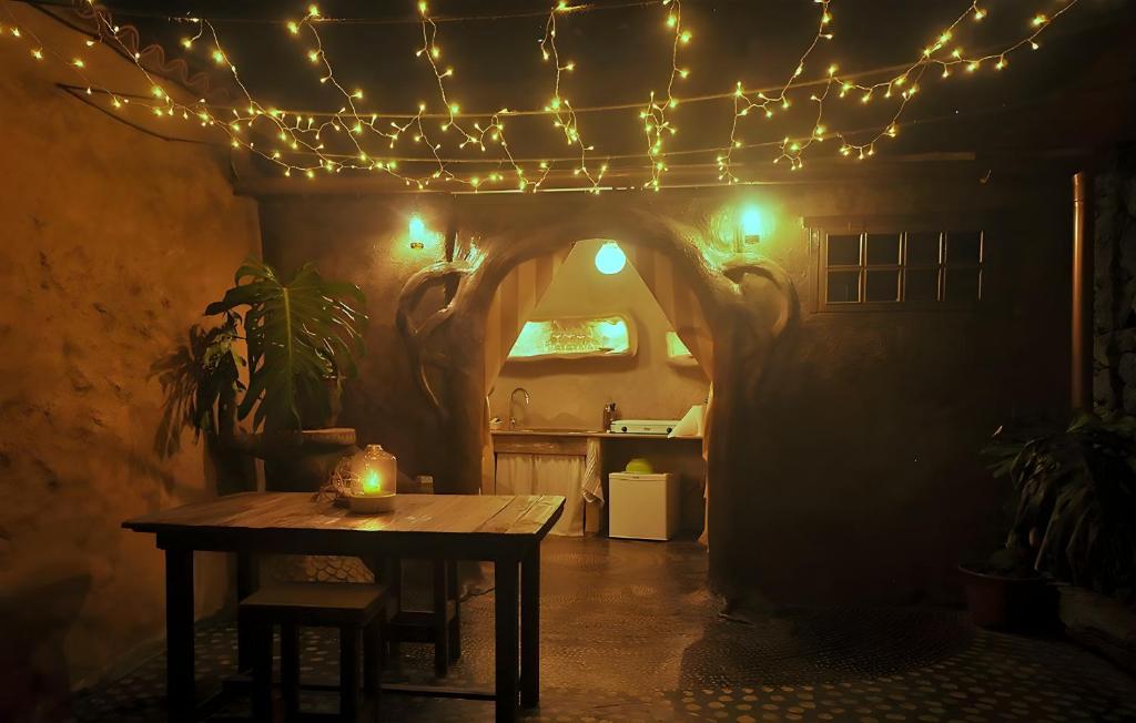 Studio Mazo La Cuevita في Mazo: غرفة طعام مع طاولة وأضواء حبلية
