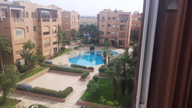 a view of a swimming pool from a window at coquette appartement meublé mimosas in Mohammedia