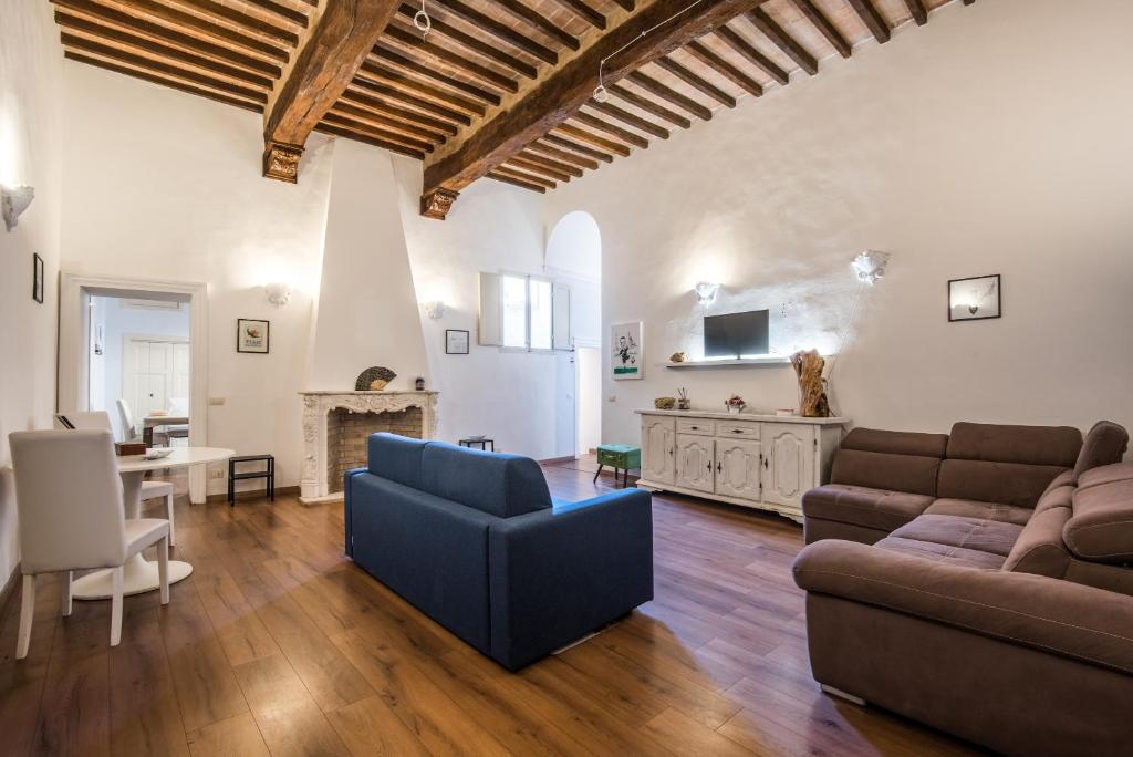 un salon avec un canapé et une table dans l'établissement Incantevole Appartamento Banchi di Sopra, à Sienne