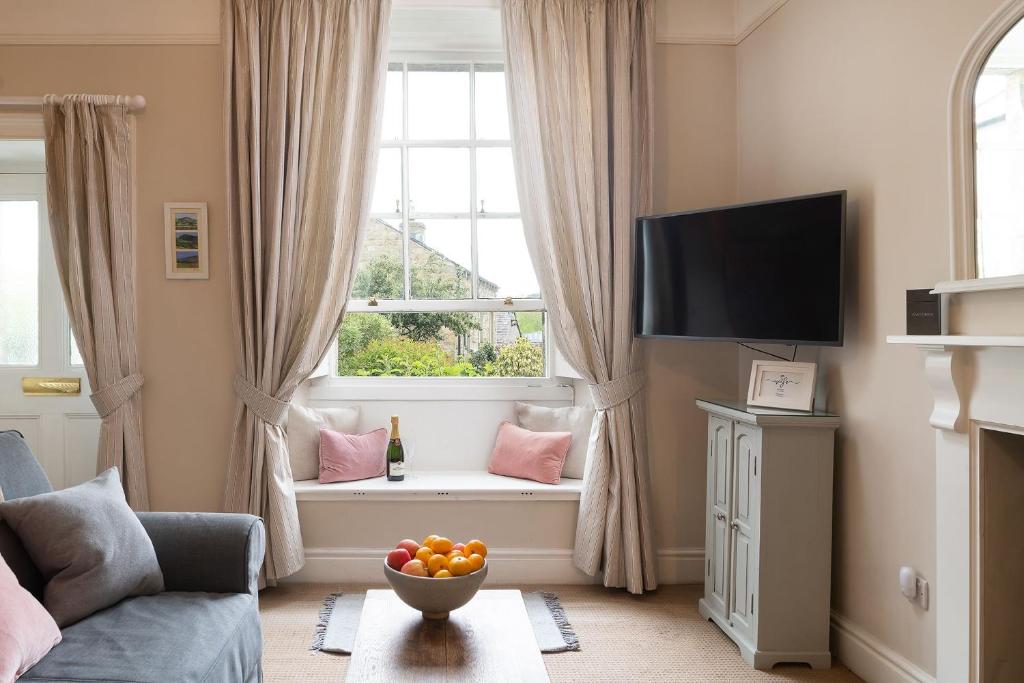 a living room with a window with a bowl of fruit at Pendle View Apartment in Settle