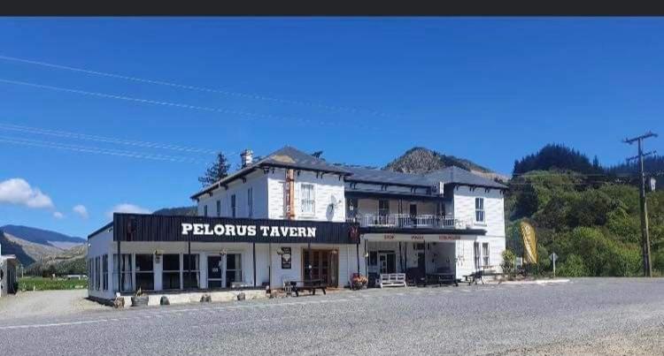 a large white building on the side of a road at The Pelorus Tavern in Havelock