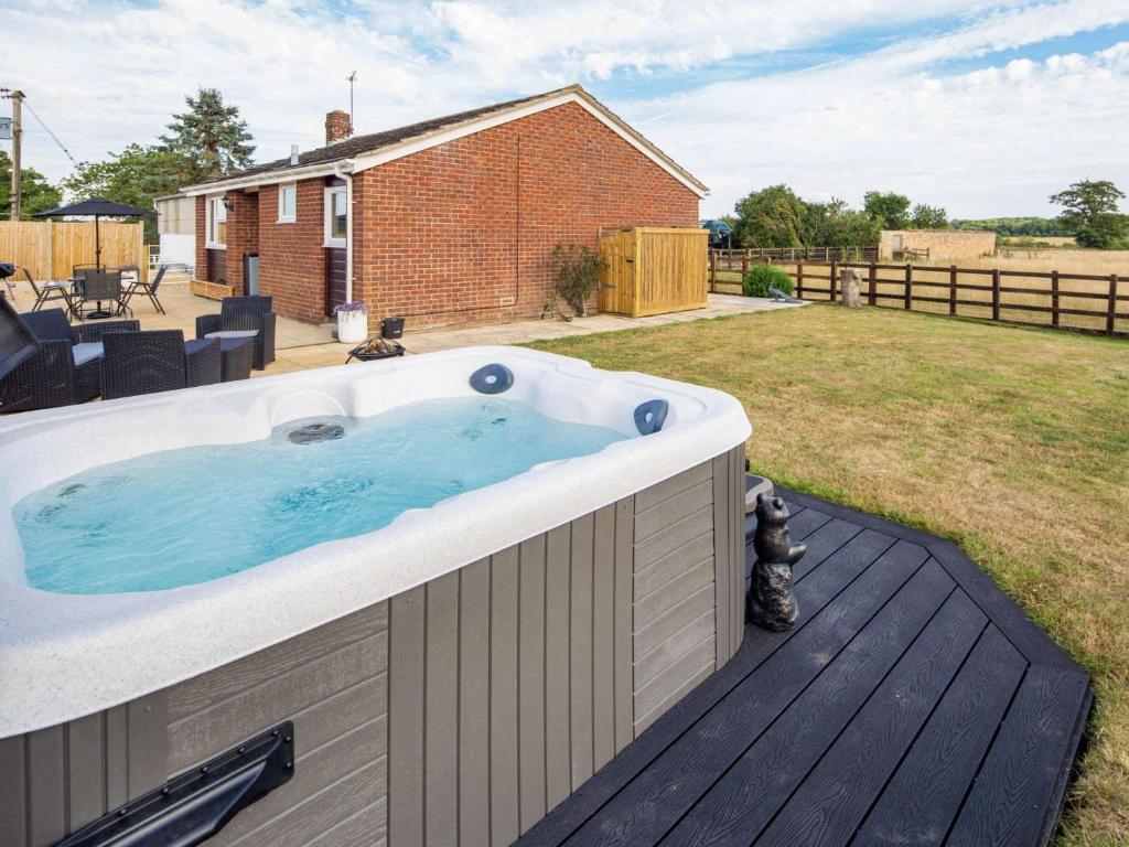 a hot tub on a deck in a yard at 3 Bed in Thame 88963 in Shabbington