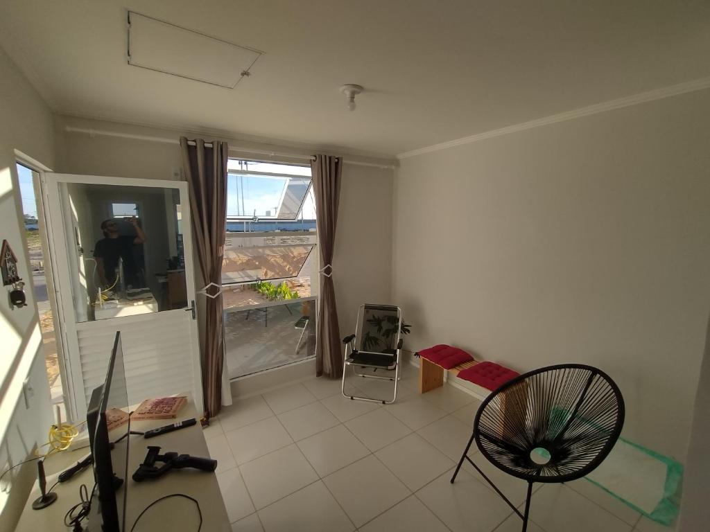 een woonkamer met een stoel en een raam bij Casa na Smart city Aquiraz (2a etapa) in Aquiraz