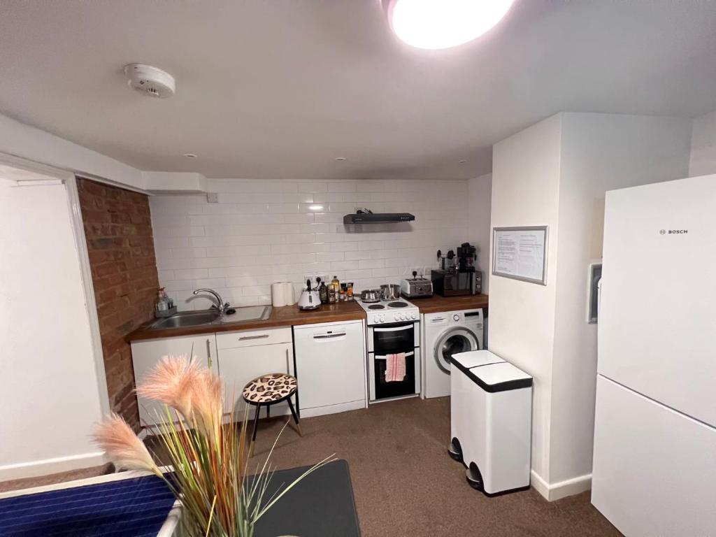 a kitchen with a stove and a washer at Comfortable Modern Home, Self Catering Flat, Newly refurbished, town centre, free parking in Cheltenham