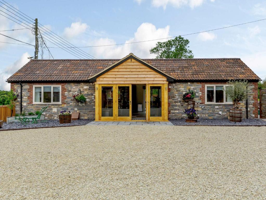 a stone cottage with yellow doors on a gravel driveway at 2 Bed in Langport 82581 in Pitney