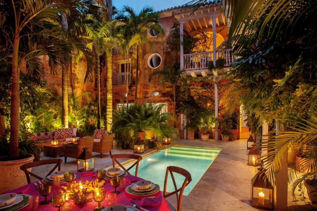 eine Terrasse mit einem Tisch und einem Pool in der Unterkunft Luxury 10 BR Colonial Mansion in Cartagena de Indias