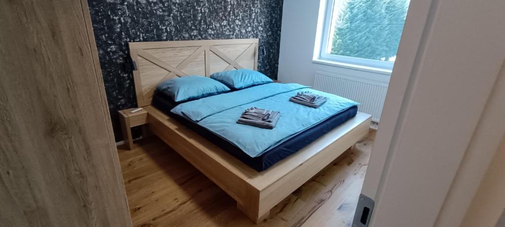 sypialnia z łóżkiem z niebieską pościelą i niebieskimi poduszkami w obiekcie Apartmán Nely w Swobodzie nad Upą