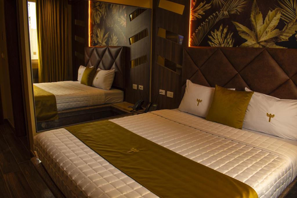 um quarto com 2 camas e um espelho em FORTICH APART HOTEL em Guayaquil