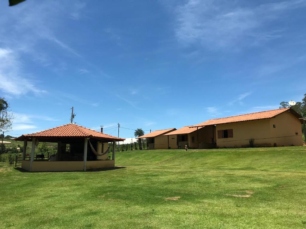 a building with a gazebo in the middle of a field at Chalé da Mata in São Roque de Minas