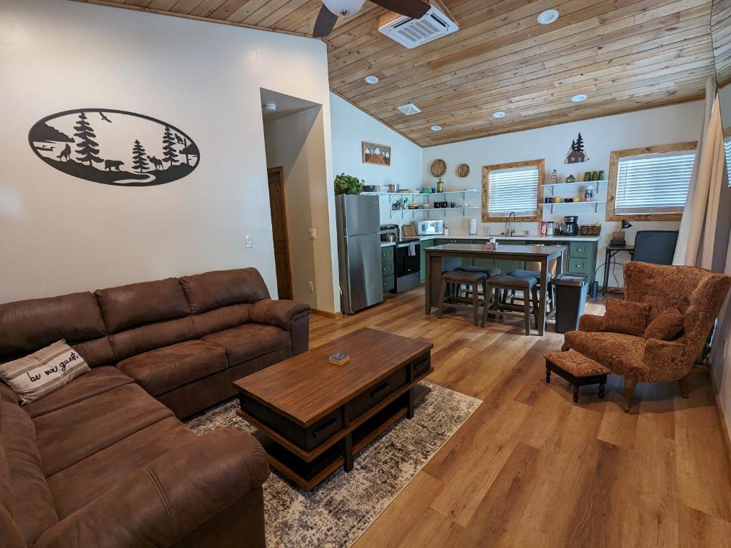 een woonkamer met een bank en een tafel bij Cozy Cottage 2BD/2BA, 2 Covered Decks, Patio Dinning, Newly Built! in Pinetop-Lakeside