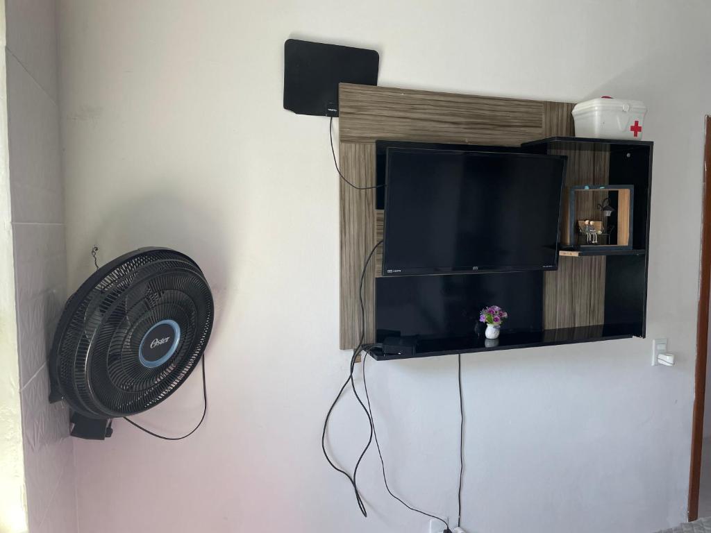 弗洛里亚诺波利斯Apartamento ingleses do rio vermelho Florianópolis的客房设有风扇和墙上的电视。