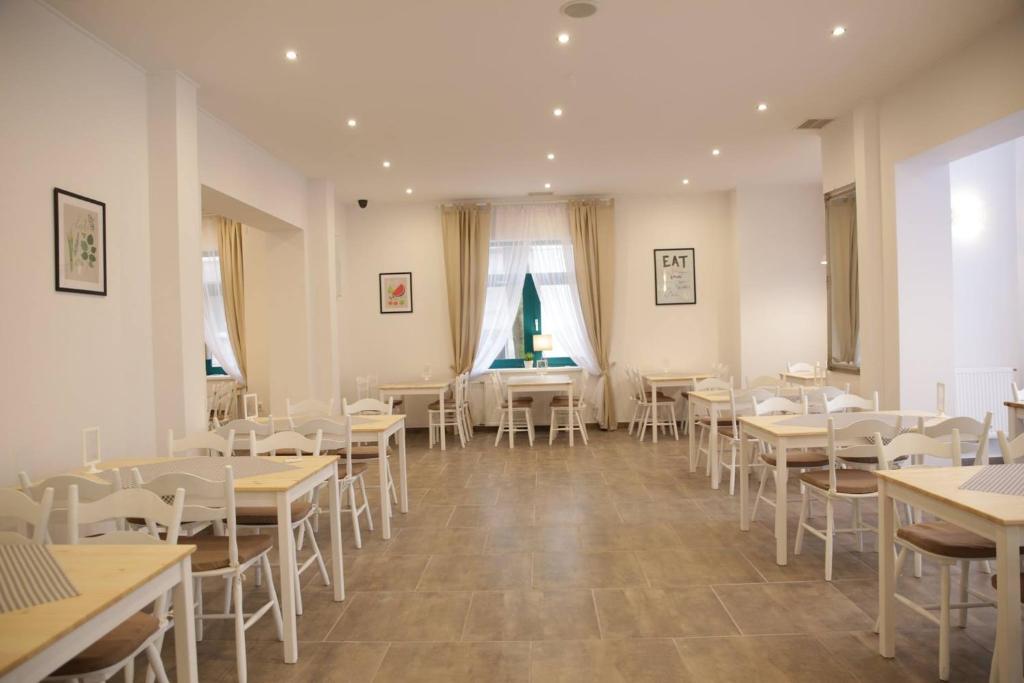 Koral Świnoujście في سفينويتشي: غرفة طعام مع طاولات وكراسي بيضاء