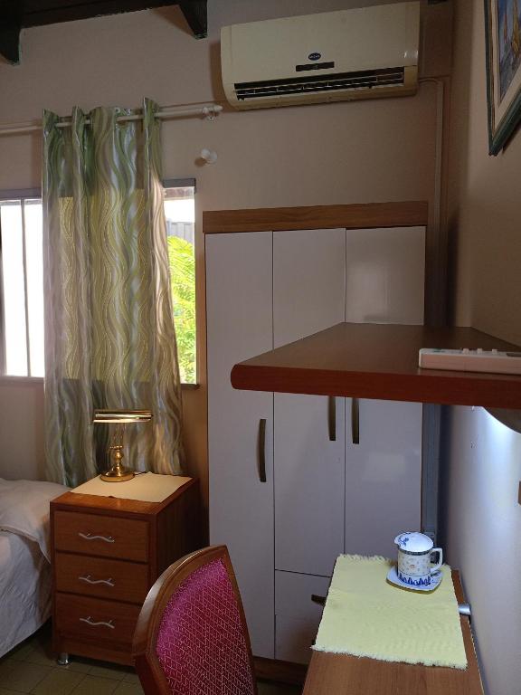 a small bedroom with a bed and a desk and a table at RESIDENCIA-UNIV in Ciudad del Este