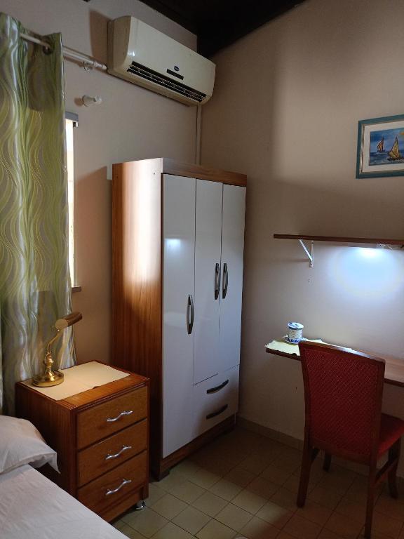 a bedroom with a bed and a desk and a cabinet at RESIDENCIA-UNIV in Ciudad del Este