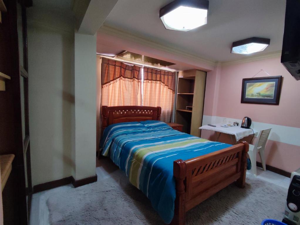 a bedroom with a bed and a table and a window at Habitacion 2 camas in Oruro