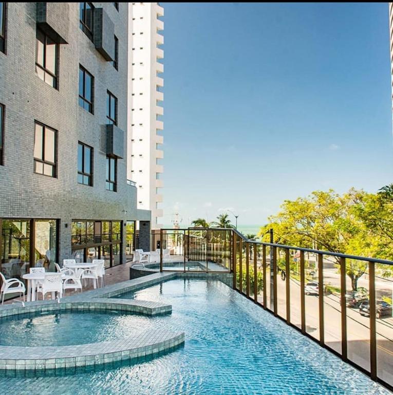 a swimming pool in front of a building at Ilusion hotel flat in Natal