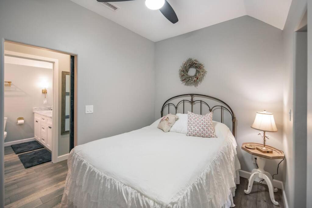 una camera con un letto bianco e un cane su un cuscino di Fawn Chalet in the Prescott Pines Near Downtown a Prescott