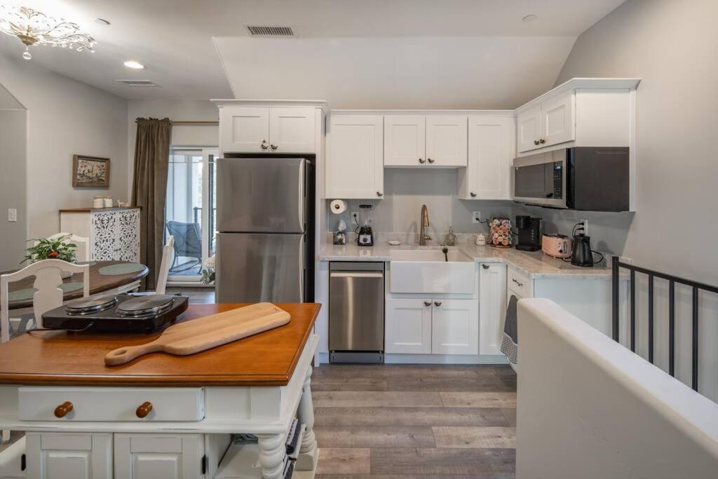 una cucina con mobili bianchi e un tavolo di legno di Fawn Chalet in the Prescott Pines Near Downtown a Prescott