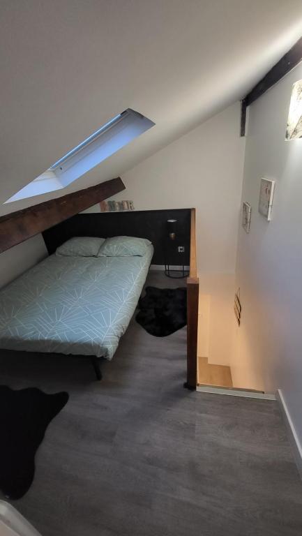 ein Schlafzimmer mit einem Bett und einem Schreibtisch in einem Zimmer in der Unterkunft Petite maison in Nogent-le-Rotrou
