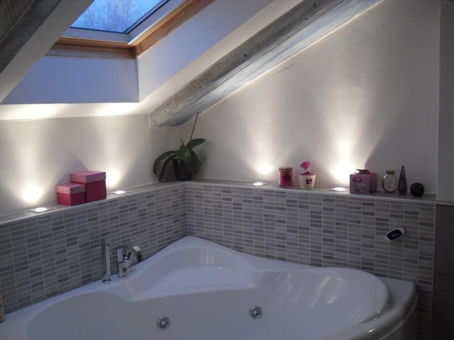 uma banheira na casa de banho com uma janela em Appartamento romantico indipendente em Gaglianico