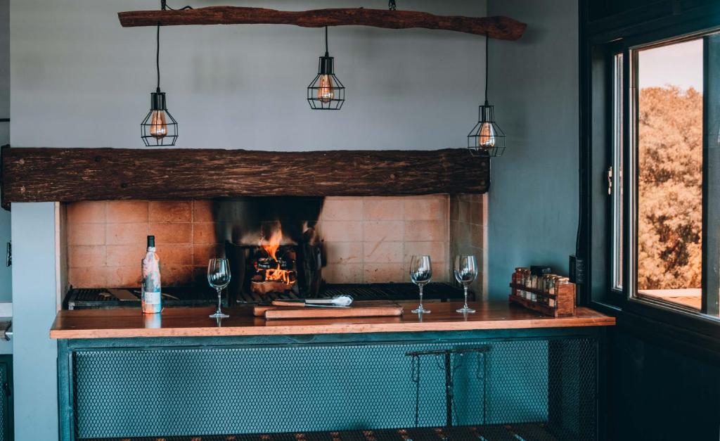 ルハン・デ・クージョにあるLa Cava Apartmentsの暖炉(ワイングラス2杯、照明付)