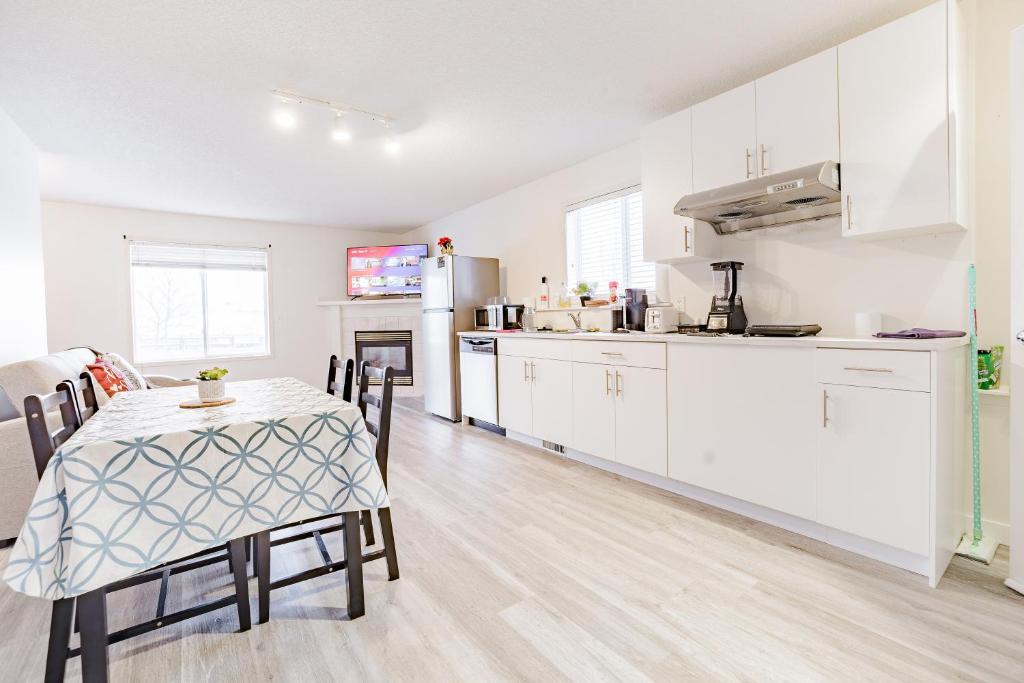 カルガリーにあるWalkout Basement Suite, 2 BDR 4BD, Bright and Spaciousのキッチン、ダイニングルーム(テーブル、テーブル、椅子付)
