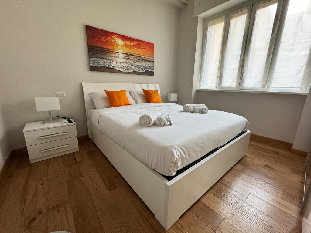 ミラノにあるSoperga10 a due passi da Stazione Centrale - Milano Real Estateのベッドルーム(オレンジ色の枕が付いた大きな白いベッド付)