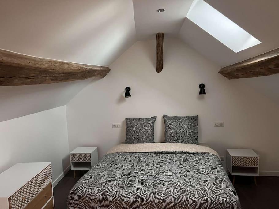 a bedroom with a large bed in a attic at Appartement Gîte Le Marmont in Châtillon-sur-Seine