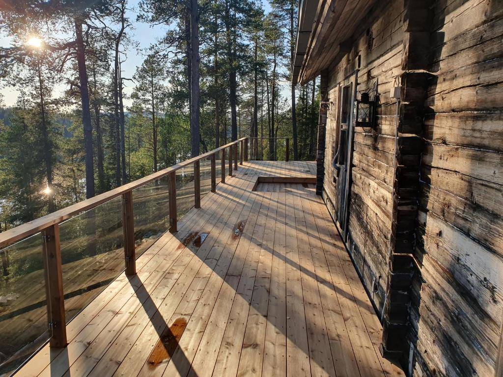 um deque de madeira ao lado de uma casa em Hilltop Villa at Lake Porontima em Kuusamo