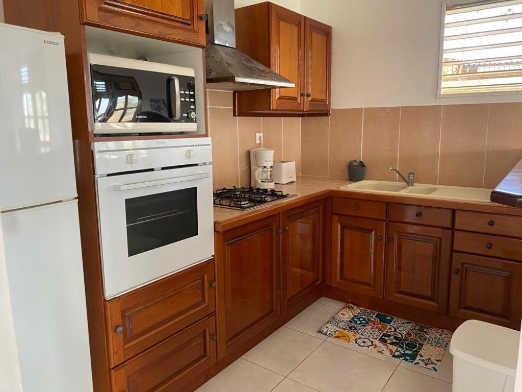 uma cozinha com armários de madeira e um forno de fogão branco em KARIFUNA em Le Souffleur