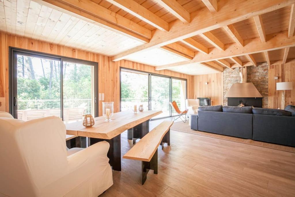 ein Wohnzimmer mit einem Tisch und einem Sofa in der Unterkunft Villa Des Sittelles - Cap Ferret in Lège-Cap-Ferret
