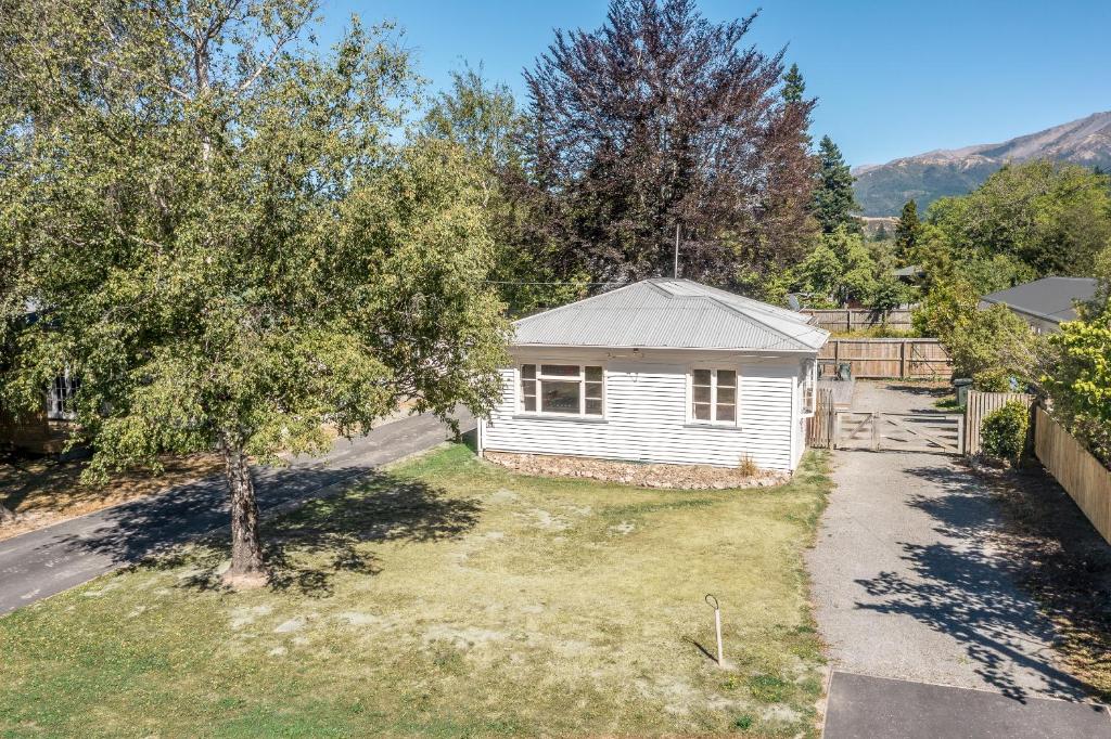 a small white house in a yard with a tree at 46 Scarborough Tce in Hanmer Springs