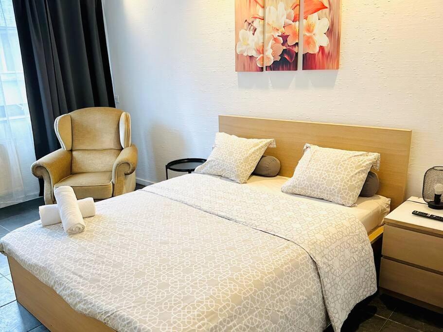 une chambre d'hôtel avec un lit et une chaise dans l'établissement Les Coulisses - Studio Hyper Central, à Liège