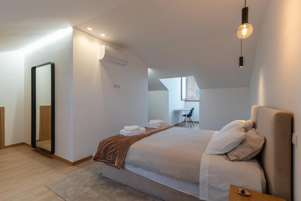 Un dormitorio con una cama grande y un espejo. en Direita House 131, en Braga