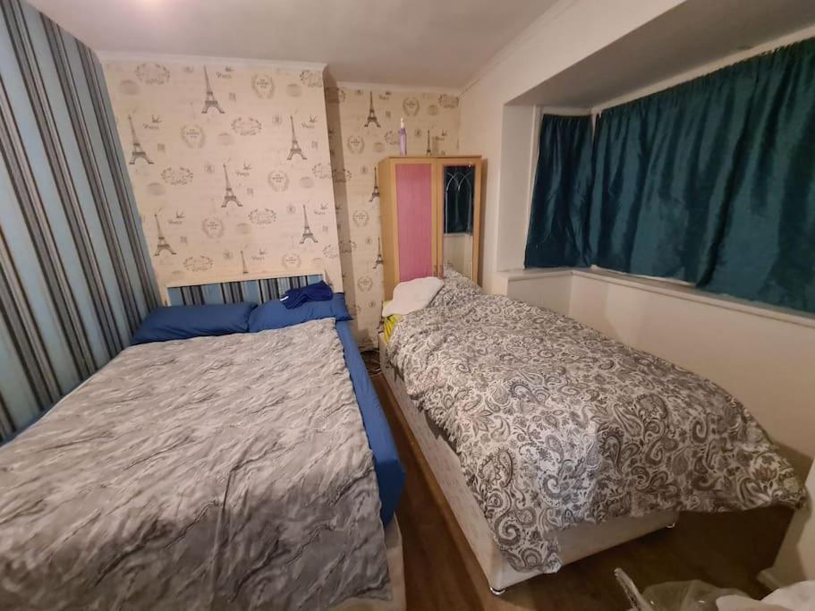 um pequeno quarto com uma cama e uma janela em Cheerful 4/5 bed house - Heathrow em West Drayton