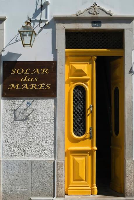 een gele deur en een bord op een gebouw bij Solar Das Marés in Fuzeta